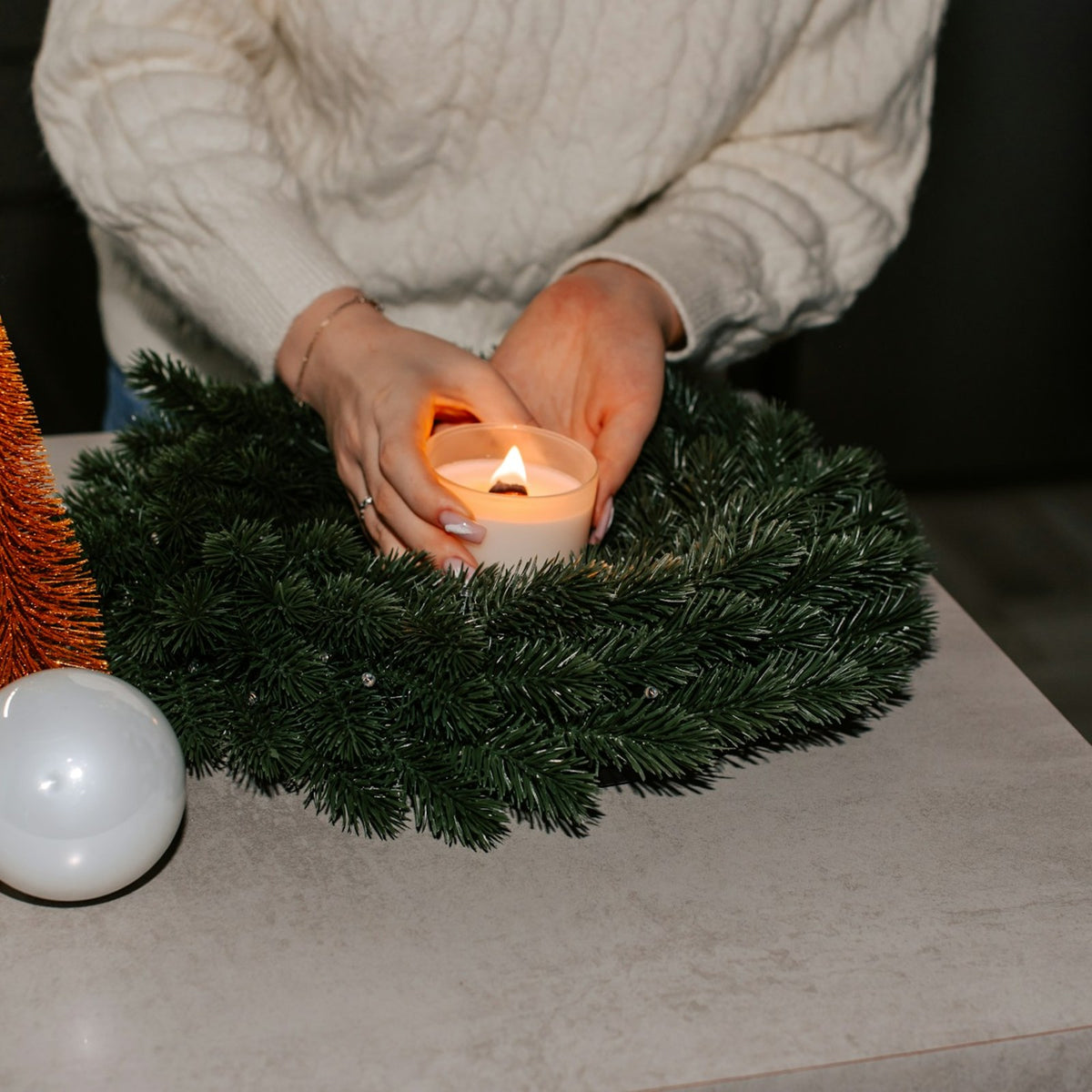 Die erste Kerze am selbstgebundenen Adventskranz wird angezündet